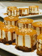 Riad La Luna caramel-topped mini cheesecakes with creamy layers on a white platter, garnished with crushed nuts
