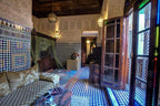 Traditional Moroccan-style room at Riad Salam Fes featuring intricate tilework, carved wood, patterned fabrics, and decorative archways