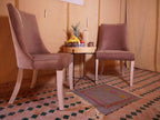 Royal Luxury Camp seating area with two brown upholstered chairs, a small black metal table with fruit, and a patterned floor mat