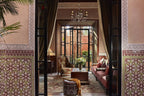 Elegant Moroccan riad interior at Royal Mansour Marrakech featuring intricate tilework, carved wood, upholstered furniture, and natural light