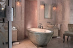 Luxury bathroom at Royal Mansour Marrakech featuring a silver ornate freestanding bathtub, marble walls, elegant vanity, and plush chair