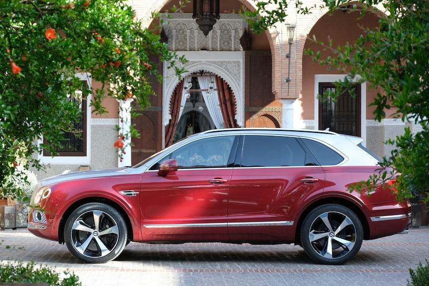 Royal Mansour Marrakech with a luxury red and white SUV parked in front featuring shiny black and silver wheels