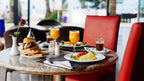 Royal Mirage Agadir restaurant table with breakfast plates, bread, orange juice, coffee, and red upholstered chairs