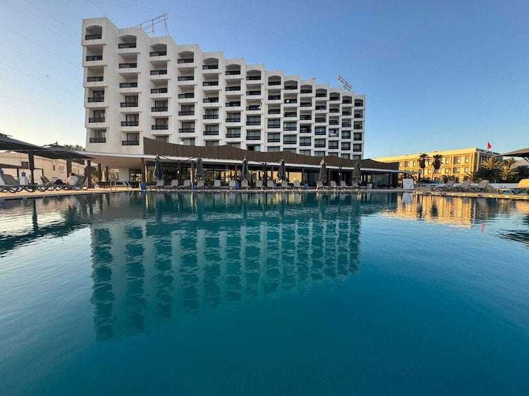 Royal Mirage Agadir hotel with white multi-storey balconies beside a large outdoor swimming pool
