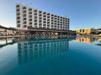 Royal Mirage Agadir hotel with white multi-storey balconies beside a large outdoor swimming pool
