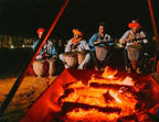 Sahara dunes Luxury Camp drummers in traditional attire with colorful turbans playing drums around a campfire at night
