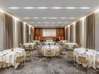 Sofitel Marrakech Palais Imperial & Spa elegant conference room with round tables, beige chairs, carpeted floor, and wall curtains