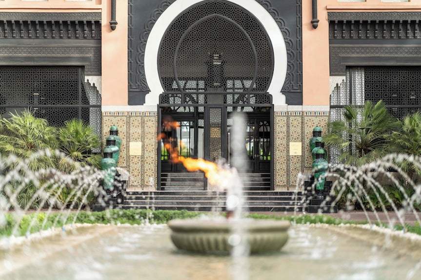 Sofitel Marrakech Palais Imperial & Spa entrance with Moroccan architectural details, decorative tiles, ornate archway, and central fountain with flame
