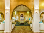 Sofitel Marrakech Palais Imperial & Spa lobby with elegant Moroccan-style golden arches, white sofas, turquoise cushions, and decorative lighting