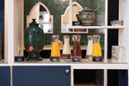 Beverage station at The Central House Marrakech Medina with glass dispensers containing pineapple juice, soy milk, apple juice, and orange juice in clear glasses