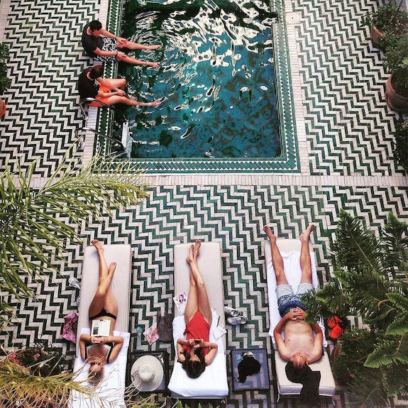 The Central House Marrakech Medina outdoor pool with geometric patterned tile floor and sun loungers surrounding the water