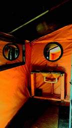 Tigmi Standard Desert Camp orange tent interior with two round mirrors and a double basin washstand in simple rustic style