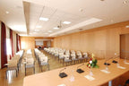 Conference room with multiple beige chairs, wooden panel walls, long table with microphones and flower centerpiece at Timoulay Hotel & Spa Agadir