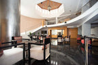 Spacious modern hotel lobby with black marble flooring, circular staircase, wooden accents, and Timoulay Hotel & Spa Agadir branding