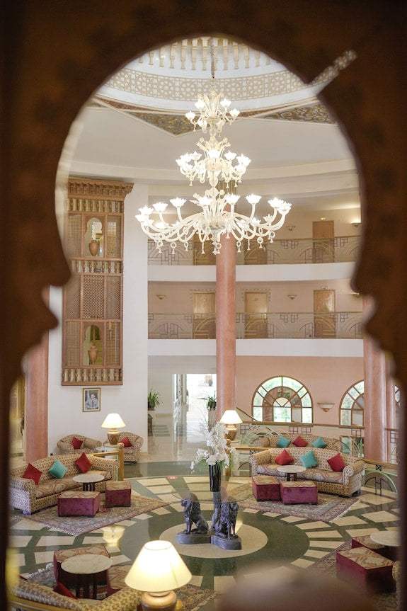 Spacious hotel lobby with Moroccan architectural details, ornate chandelier, patterned floor, and comfortable seating at Timoulay Hotel & Spa Agadir
