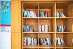 Wooden bookshelf with multiple compartments filled with assorted books in a library area at Timoulay Hotel & Spa Agadir
