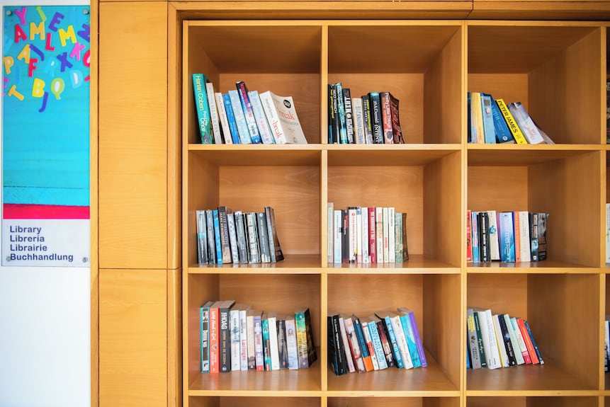 Wooden bookshelf with multiple compartments filled with assorted books in a library area at Timoulay Hotel & Spa Agadir