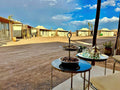Yes We Camps Luxury Lodge & Spa outdoor desert lounge area with beige tents, metal tables with Moroccan tea set and pastries